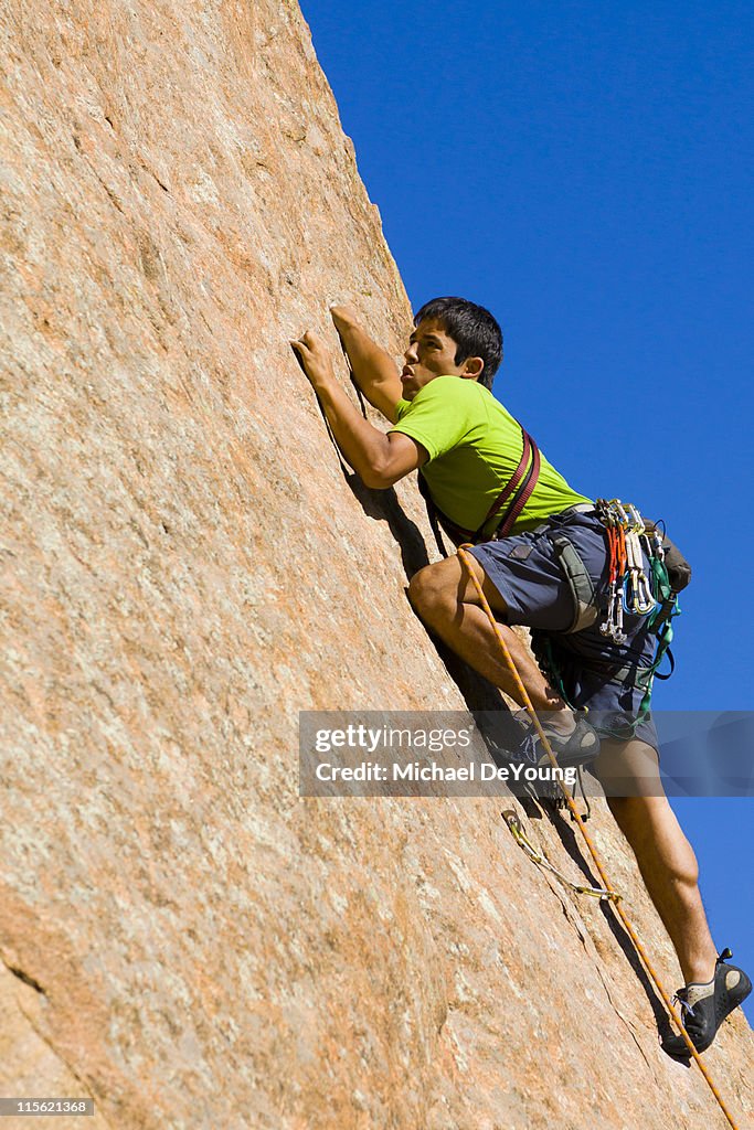 Hispanic man rock climbing