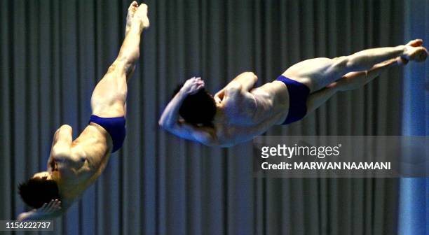 Chinese divers Wang Kenan and Peng Bo flip in the air in the final of the men's 3m sychronized diving event, 09 October 2002, at Sajik pool in Busan...