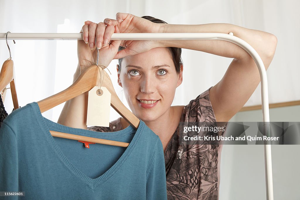 Woman holding clothing rail