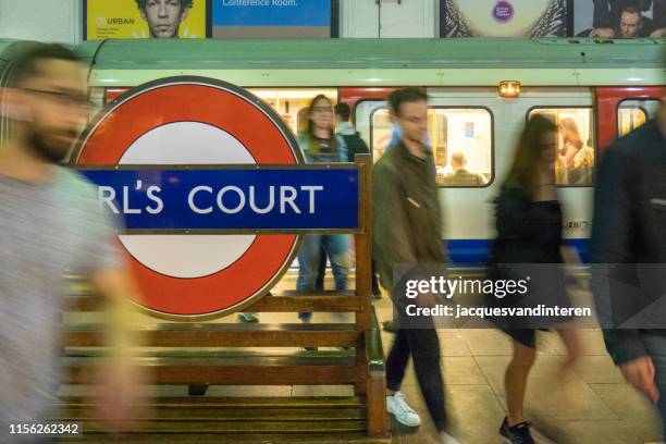 gente di fretta in una stazione della metropolitana di londra. allenati sullo sfondo. - earls court london foto e immagini stock