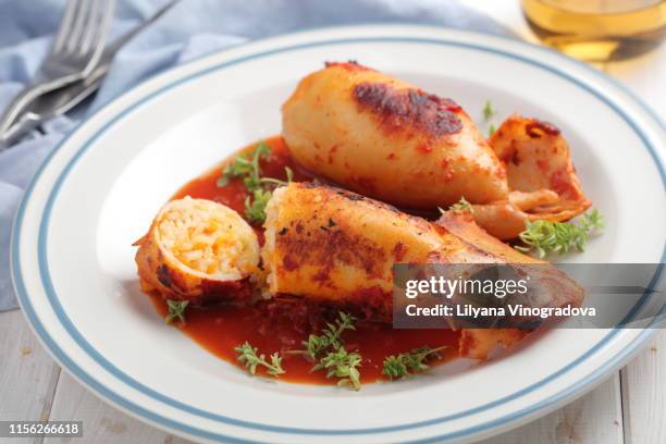 stuffed squids under tomato sauce served with white wine - calamari stock pictures, royalty-free photos & images