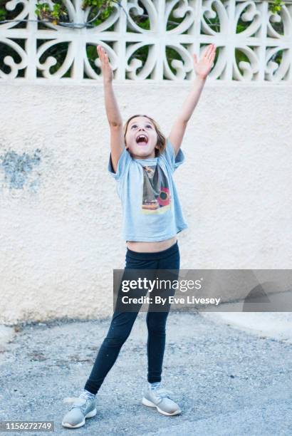 young girl with arms stretched upwards - girls in leggings stockfoto's en -beelden