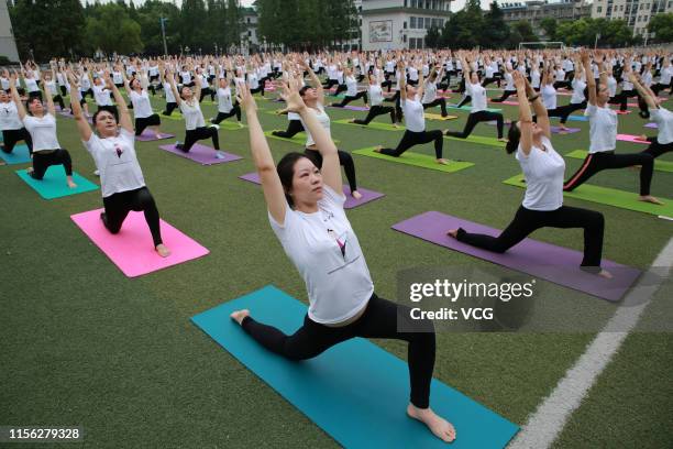 Hundreds of yoga enthusiasts practice Yoga at a school ahead of International Day of Yoga on June 16, 2019 in Xiangyang, Hubei Province of China.