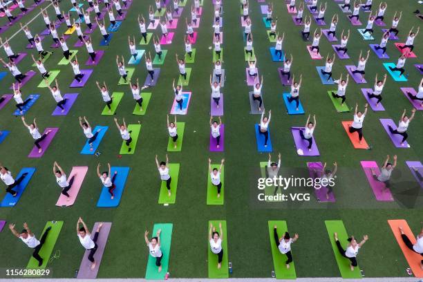 Hundreds of yoga enthusiasts practice Yoga at a school ahead of International Day of Yoga on June 16, 2019 in Xiangyang, Hubei Province of China.