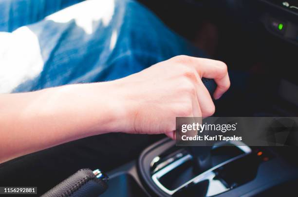 a young man is driving a car - automatic photos et images de collection