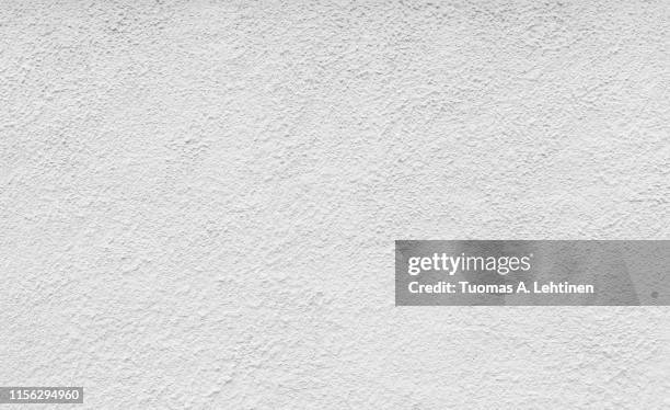 high resolution full frame background of a rough plastered concrete wall in black and white. - uneben stock-fotos und bilder