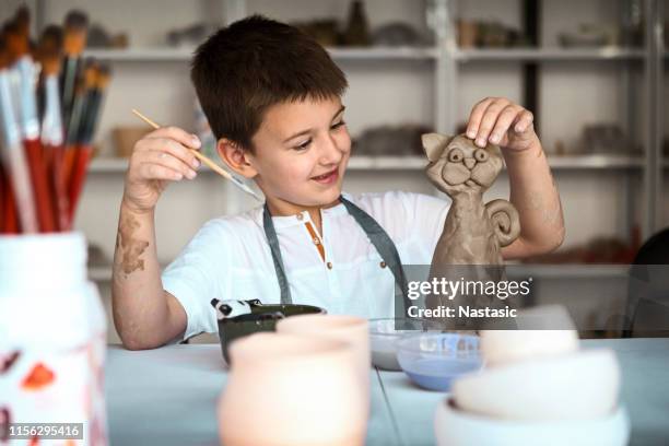 child on pottery class molding shape and painting clay - sculptor stock pictures, royalty-free photos & images