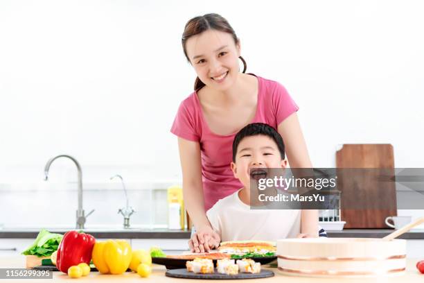 young boy learning to make sushi hand roll - nori stock pictures, royalty-free photos & images