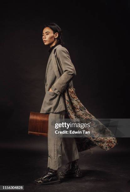 an asian chinese male standing carrying a briefcase looking away - asain model men stock pictures, royalty-free photos & images
