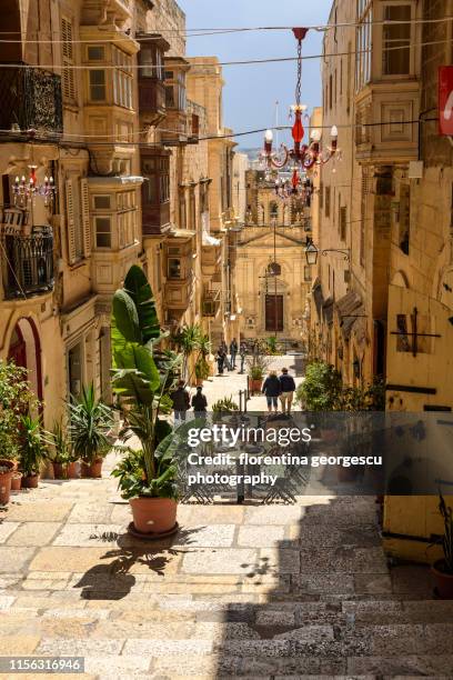 typical enclosed maltese balconies flanking a narrow cobbled alley with steps to the grand harbor, valletta, malta - valletta 個照片及圖片檔