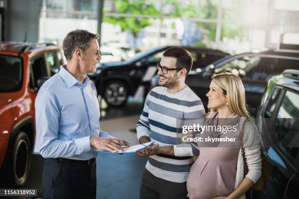 很高興期待夫婦與經理溝通,同時在展廳買車。 - buying a car 個照片及圖片檔