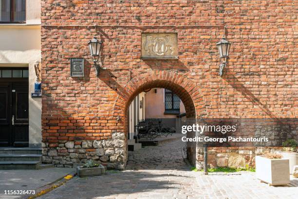 old brick wall with gate in riga, latvia - brick foto e immagini stock