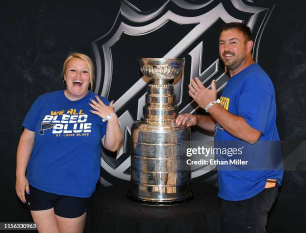 St. Louis Blues fans Jamie Maddox and Bryan Maddox of Missouri show off their wedding rings as they pose with the Stanley Cup at MGM Grand Hotel &...