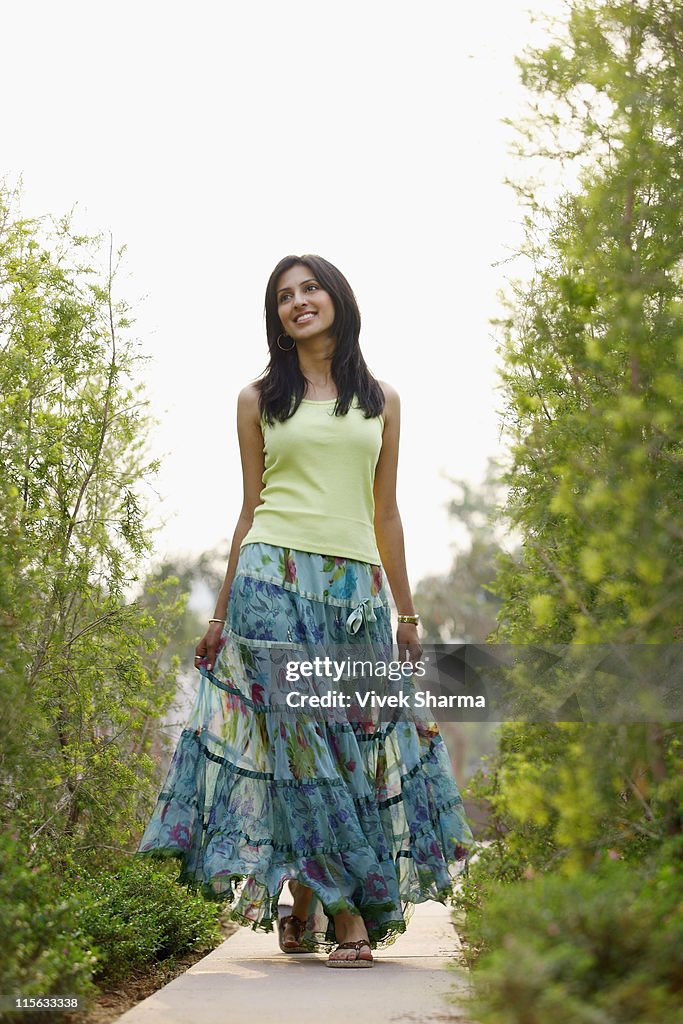 Woman in flowing skirt, walking on pathway