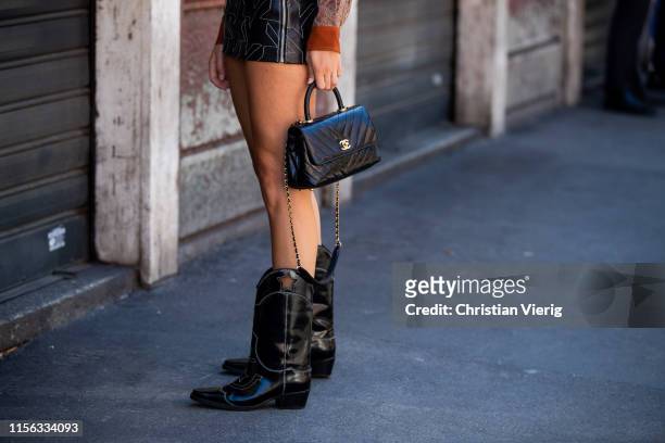 Xenia Adonts is seen wearing black mini skirt, bag, cowboy boots outside Etro during the Milan Men's Fashion Week Spring/Summer 2020 on June 16, 2019...