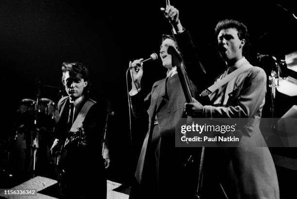 View of, from left, English New Wave musicians Martin Kemp, on bass guitar, singer Tony Hadley, and Gary Kemp, on guitar, all of the group Spandau...