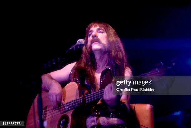 American comedian Harry Shearer, in costume as British musician Derek Smalls of the group Spinal Tap, plays bass guitar as he performs onstage during...