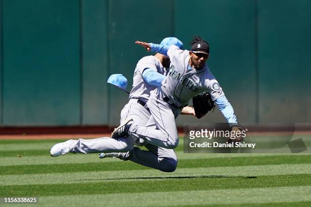 Crawford of the Seattle Mariners collides with Mac Williamson as he catches a fly ball for an out during the sixth inning against the Oakland...