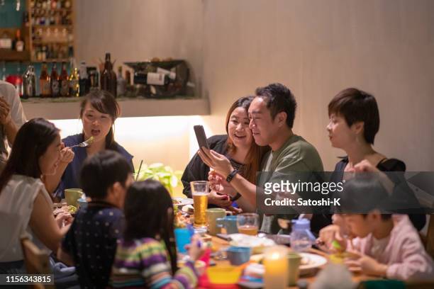happy vrienden en families op dinner party - taichung stockfoto's en -beelden