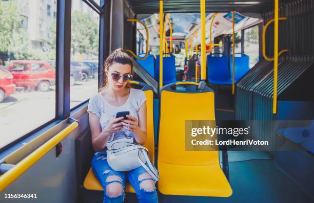 mujer usando teléfono inteligente en el autobús - asiento fotografías e imágenes de stock