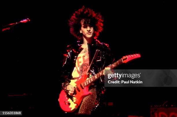 American Rock musician Steve Stevens plays guitar as part of Billy Idol's band during the 'Rebel Yell' tour at the Poplar Creek Music Theater,...