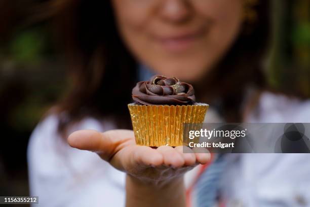 woman holding tasty chocolate cupcake - tasty chocolate stock pictures, royalty-free photos & images