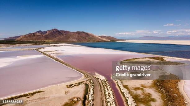 a sweeping drove view of the pink and white salt reservoirs near antelope island near the great salt lake in utah - great salt lake stock pictures, royalty-free photos & images