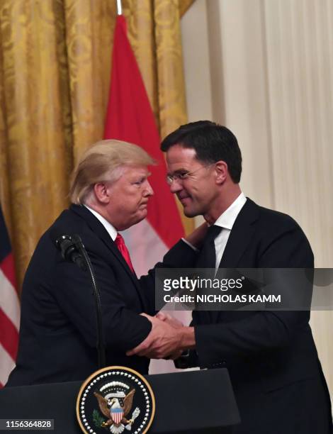 President Donald Trump embraces Dutch Prime Minister Mark Rutte during an East Room ceremony at the White House in Washington, DC, on July 18, 2019....