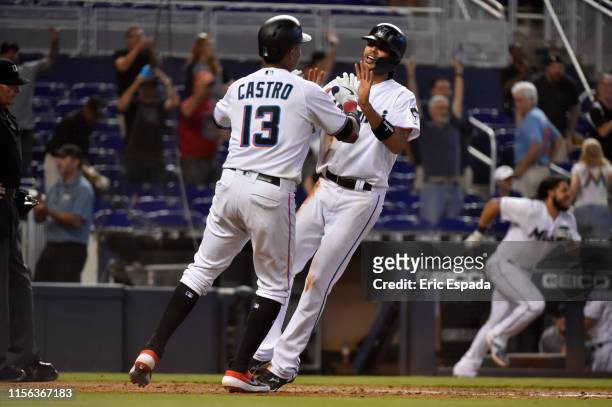 Yadiel Rivera of the Miami Marlins celebrates with Starlin Castro after scoring the game winning run in the ninth inning to defeat the San Diego...