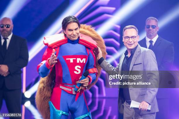 July 2019, North Rhine-Westphalia, Cologne: Model Marcus Schenkenberg stands on stage as a "squirrel" alongside presenter Matthias Opdenhövel at the...
