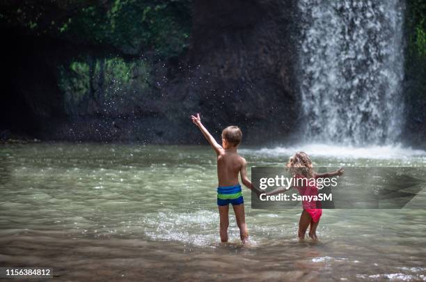 happy kids enjoying in nature - bali waterfall stock pictures, royalty-free photos & images