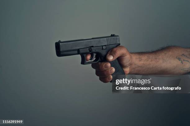 man with gun - handgun stock pictures, royalty-free photos & images