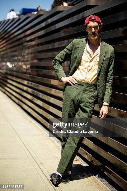 Richard Biedul, wearing a green suit, yellow shirt, black loafers and red hat, is seen during Pitti Immagine Uomo 96 on June 13, 2019 in Florence,...