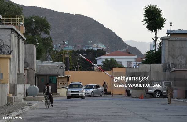 In this photo taken on June 19 Afghan security personnel check vehicles at a gate in the Green Zone in Kabul. - A labyrinth of concrete blast walls,...