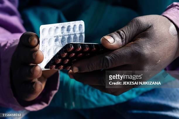 Blessing Chingwaru an HIV positive TB patient, holds a packet of tablets received as part of his treatment at Rutsanana Polyclinic in Glen Norah...