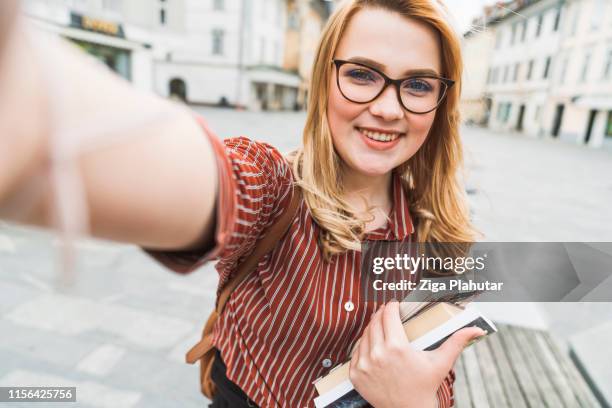 lächelnder frischling frau college-studentin, die ein selfie macht - student buch lernen stock-fotos und bilder