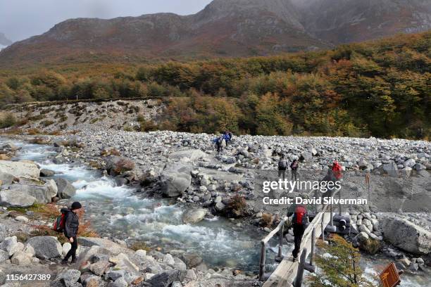 Tourists cross the Río Blanco at the start of their ascent to Laguna de los Tres on the Fitz Roy mountain during their 9-hour, 20 kilometer trek from...