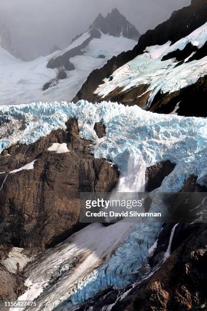 Glacial ice breaks off in a small avalance from the Piedras Blancas glacier, one of the low glaciers in the area that descends from Mount Fitz Roy,...