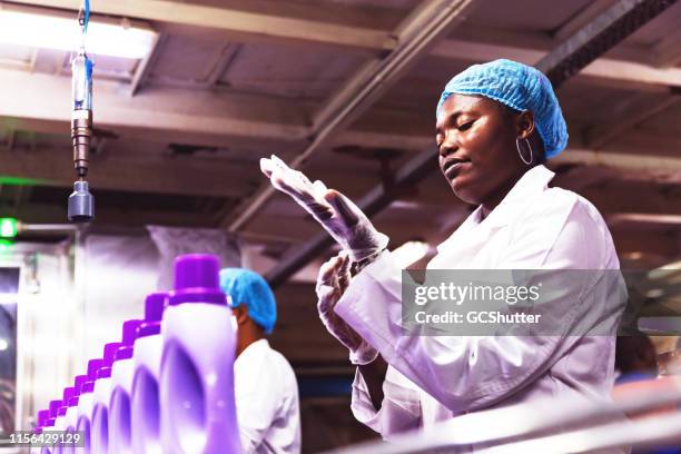 african female production line worker preparing for her shift - hair net stock pictures, royalty-free photos & images