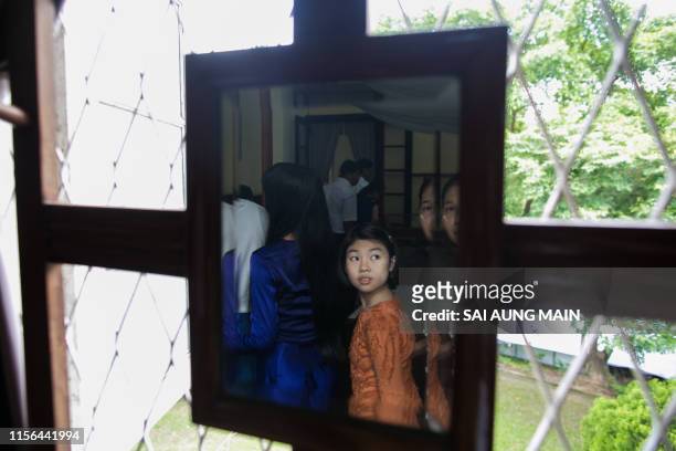 Girl with other visitors is reflected on a mirror at the General Aung San Museum, former residence of Aung San Suu Kyi's father during the Martyrs'...