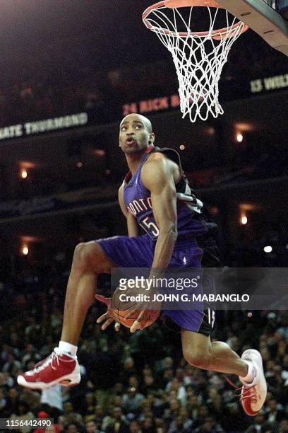 Toronto Raptors player Vince Carter passes the ball between his legs during one of his slam dunk attempts in the NBA All-Star Slam Dunk contest 12...