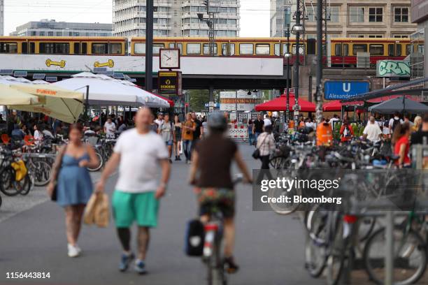 An S-Bahn city train travels on an elevated railway track over pedestrians and parked bicycles in Alexanderplatz square in Berlin, Germany, on...