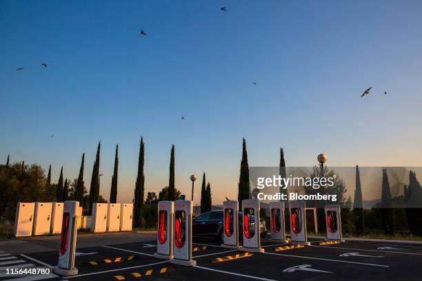 Tesla Inc. Model S electric vehicle charges at a Supercharger station as the sun sets in Sant Cugat, Spain, on Wednesday, July 10, 2019. Tesla is...