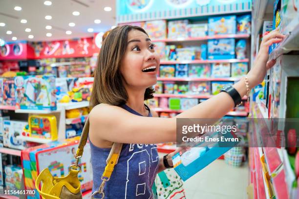 kvinna shopping i leksaks affär - leksaksaffär bildbanksfoton och bilder