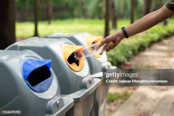 a man throw rubbish in the trash can by separate garbage to dispose like hazardous waste - people picking up trash stock pictures, royalty-free photos & images