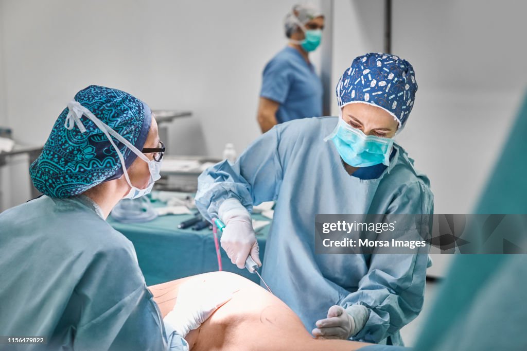 Female doctors performing surgery on patient