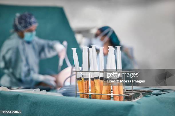 close-up of fat syringes in rack on table - liposuction stock pictures, royalty-free photos & images