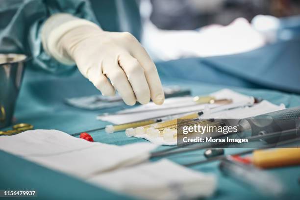 close-up of female surgeon's hand over equipment - medizinisches instrument stock-fotos und bilder