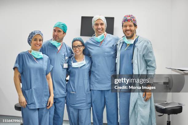 portrait of smiling surgeons standing in icu - nurse uniform stock pictures, royalty-free photos & images