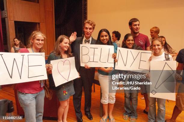 Full-length shot of science communicator Bill Nye, surrounded by fans holding "We love Bill Nye!" signs, during a Milton S Eisenhower Symposium at...